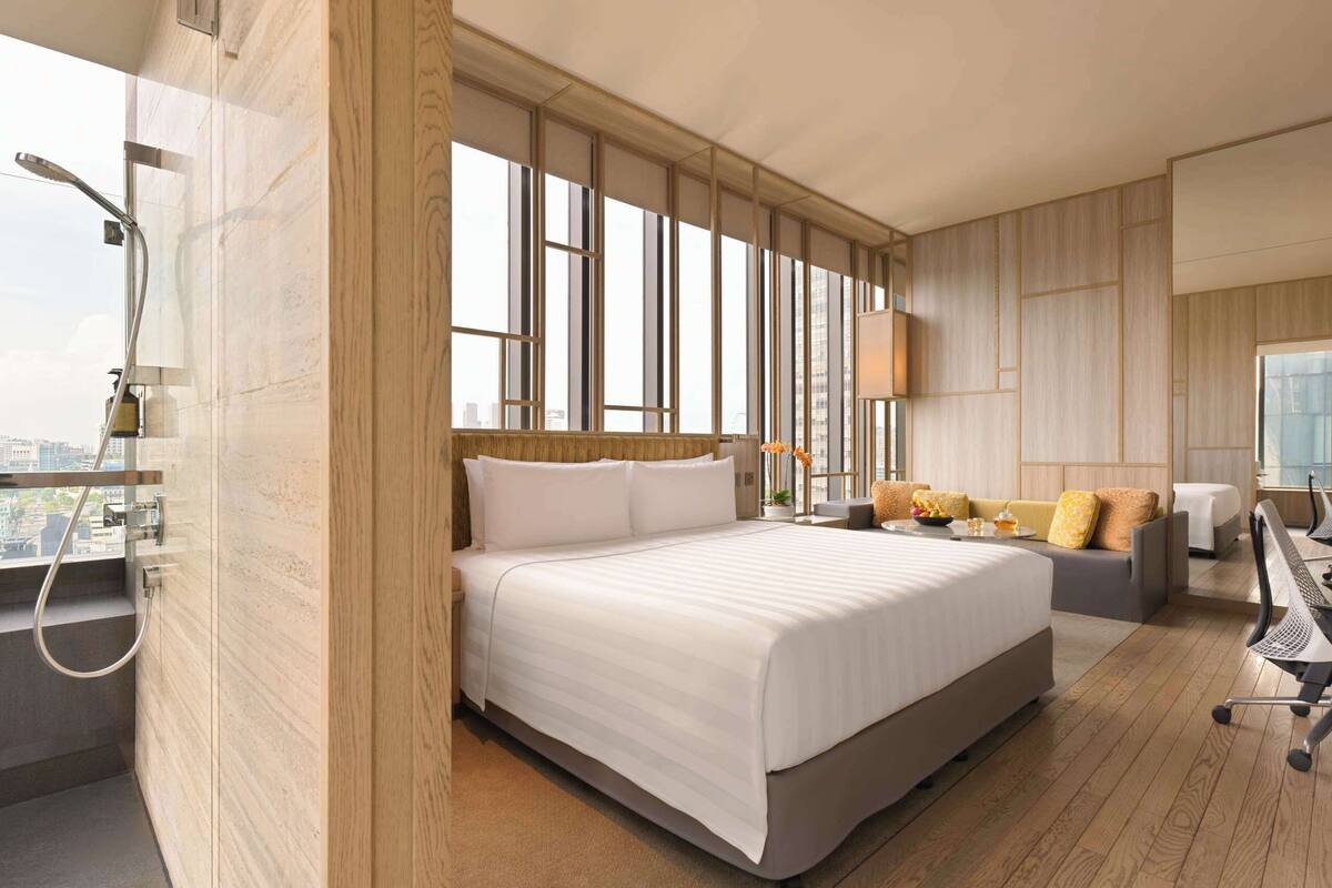 Une chambre d’hôtel moderne avec un grand lit, un bureau et une vue sur la ville.