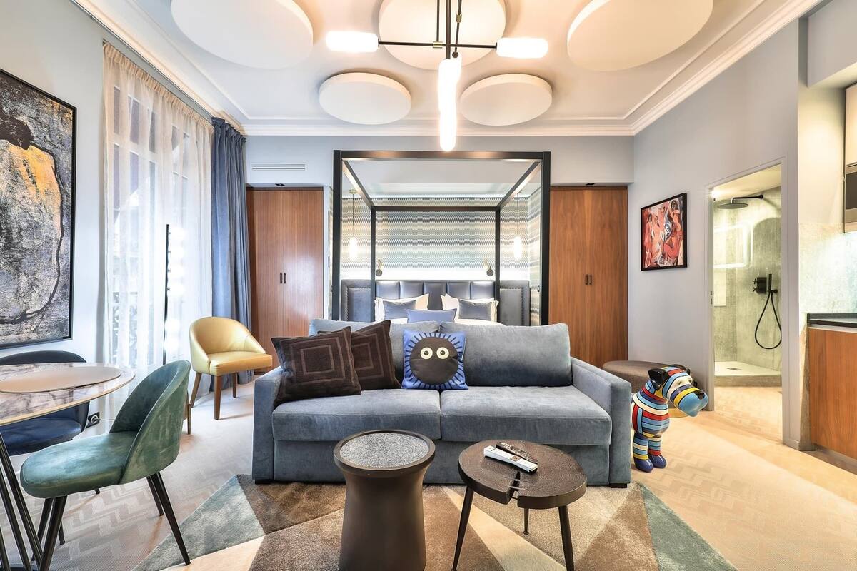 A modern living room with a grey sofa, a round coffee table, a chair, and a colorful toy.