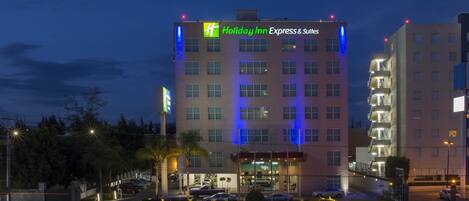 A Holiday Inn Express & Suites building with a modern design, featuring a prominent sign and multiple windows.
