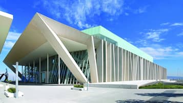 Un edificio moderno con un diseño angular distintivo, grandes ventanales y techo plano.