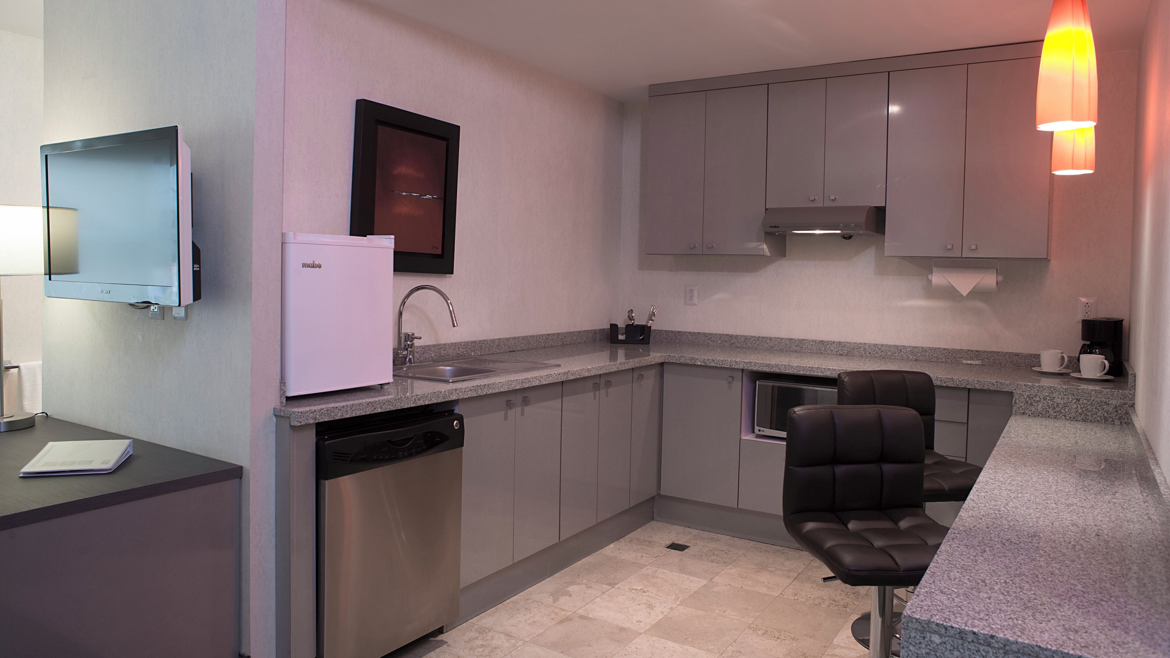 A modern kitchen with a built-in dishwasher, a microwave, and a coffee maker.