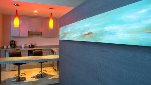 A modern kitchen with pendant lighting, a bar area, and a large abstract painting on the wall. - Holiday Inn Express Queretaro by IHG (Querétaro)