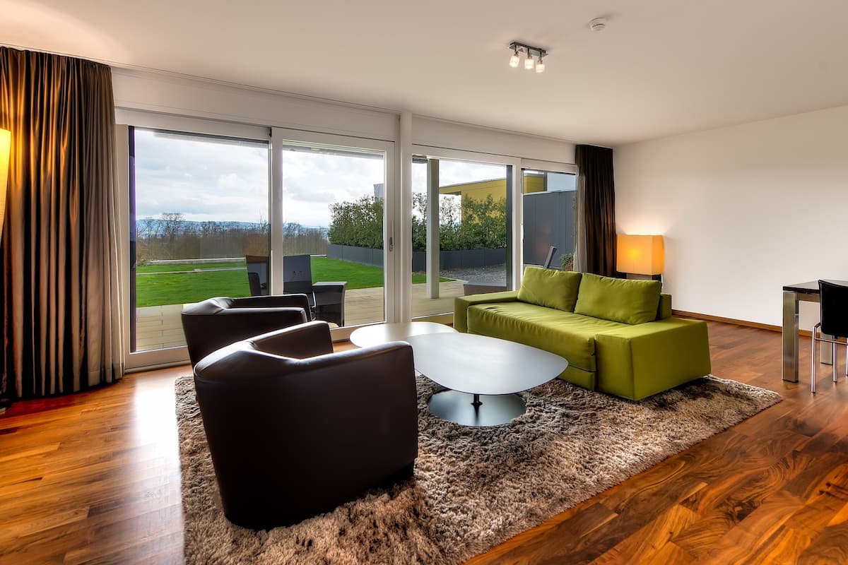 A modern living room with a sofa, chairs, a coffee table, and a dining area.