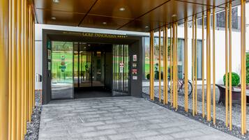 Entrada moderna de un hotel con un cartel que dice "WellnessHotel Golf Panorama".
