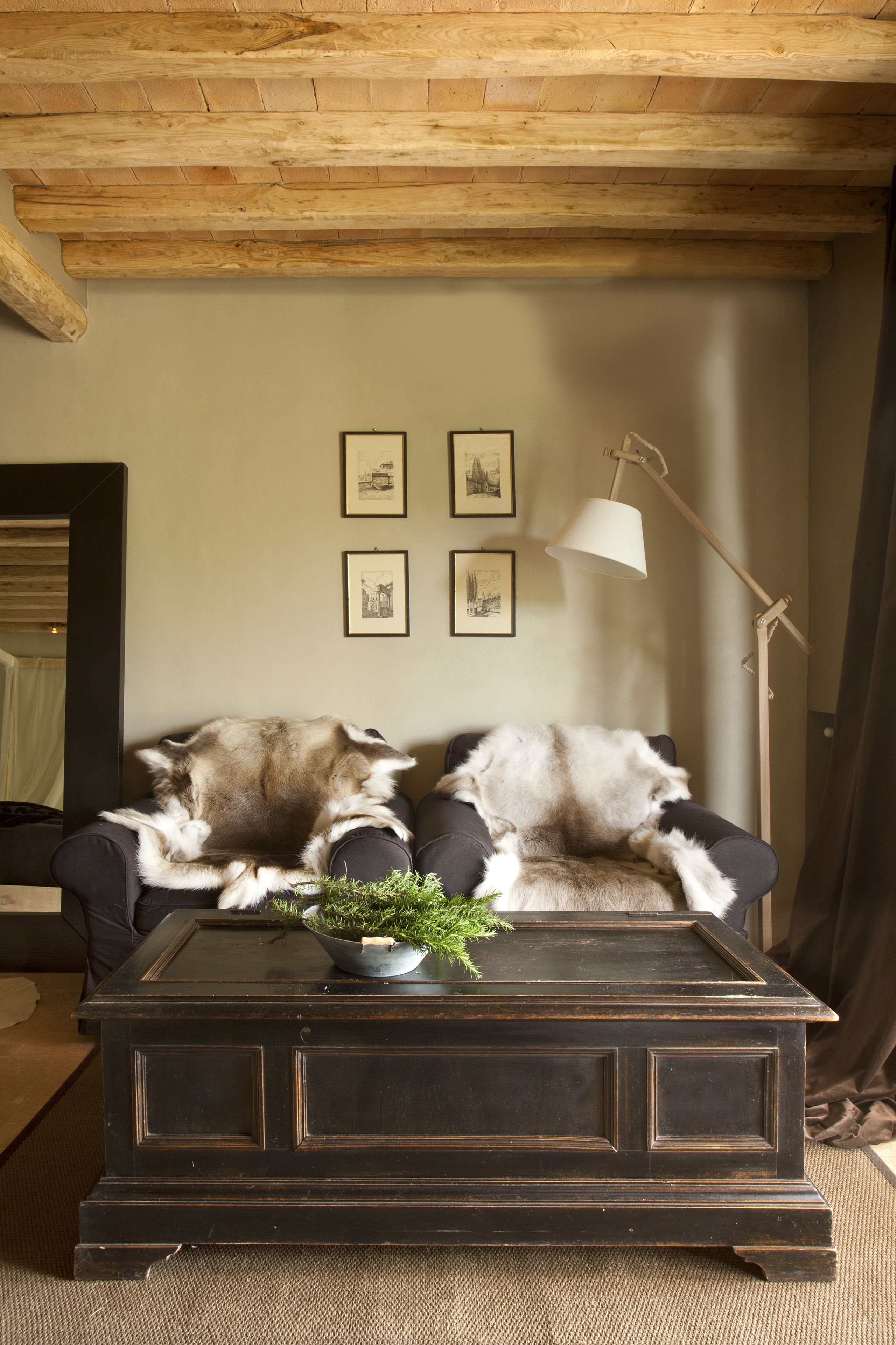 A cozy living room with a dark wooden coffee table, two plush chairs, and a floor lamp.