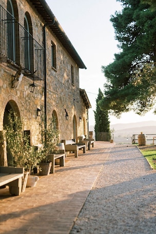 A stone building with arched windows and outdoor seating.