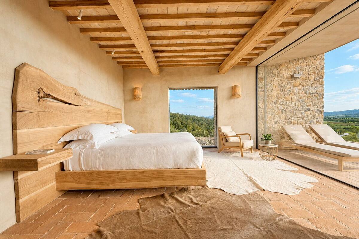 Un dormitorio con cabecera de madera, cama grande, pared de piedra y vistas al exterior.
