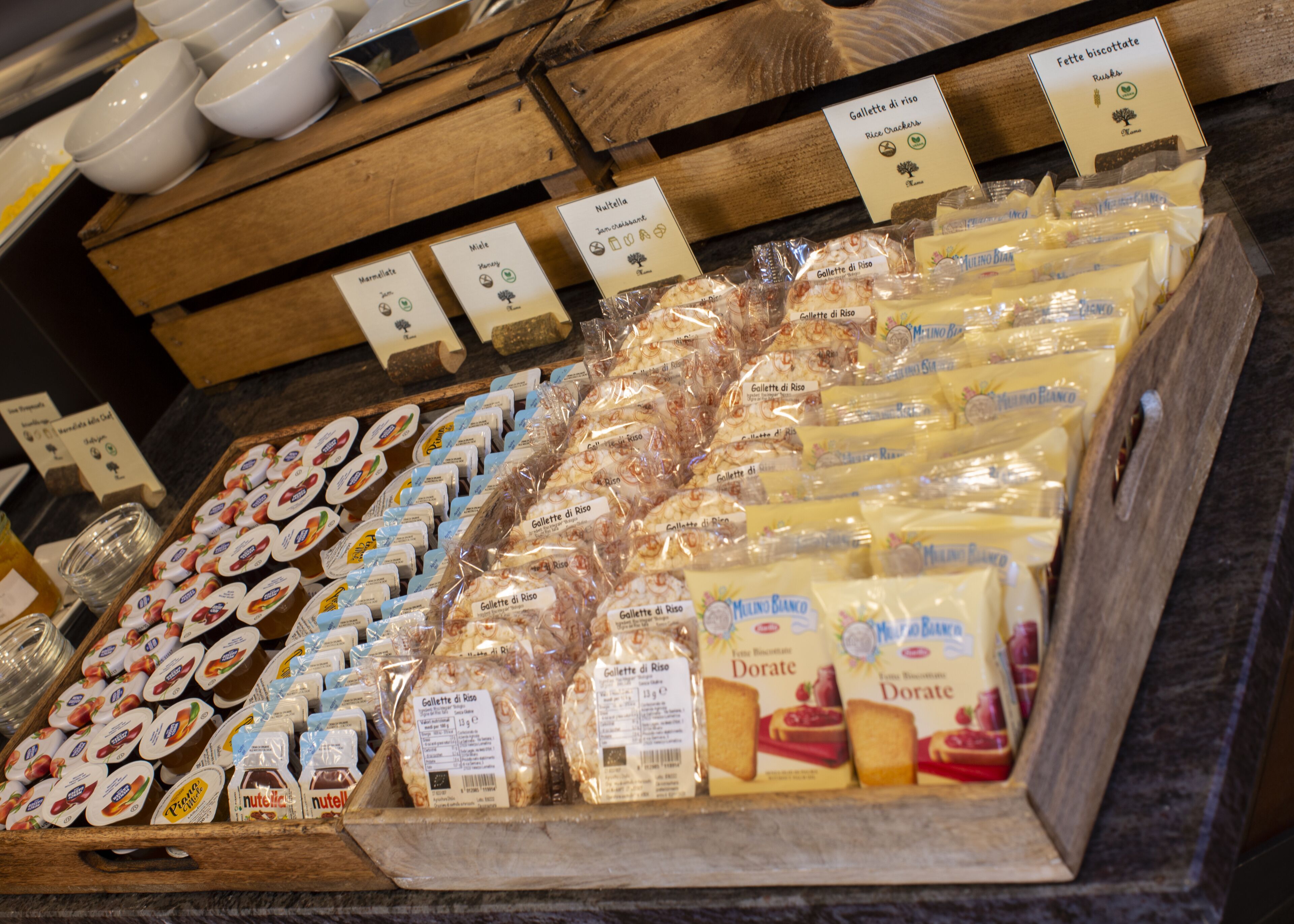 A cheese display with various types of cheese and labels.