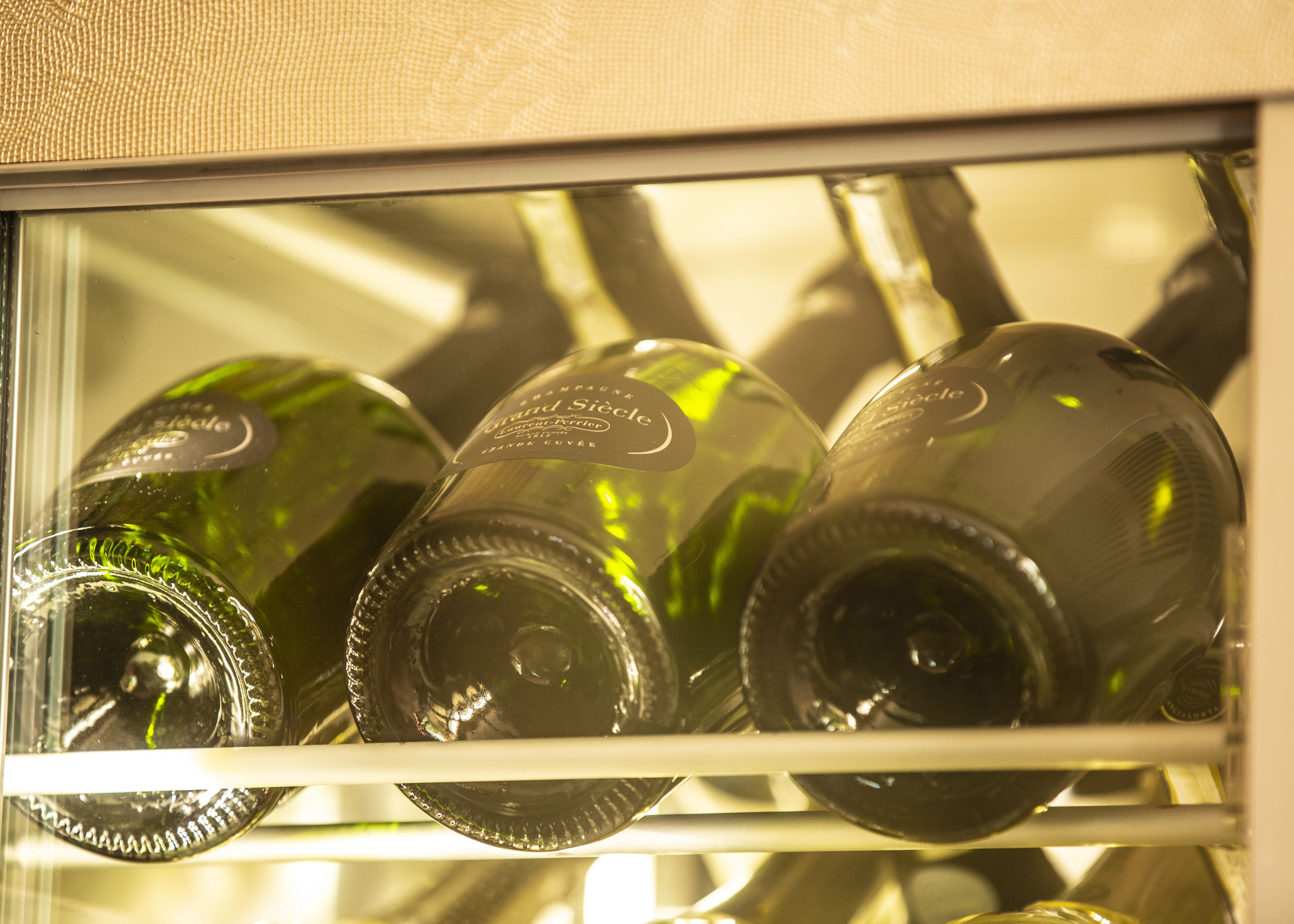 Een koelkast met verschillende champagneflessen.