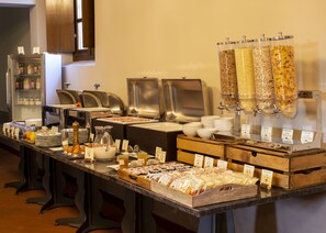 Montaje de bufé con diversos alimentos y estaciones de servicio.