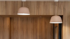 Pared de madera con dos lámparas colgantes.