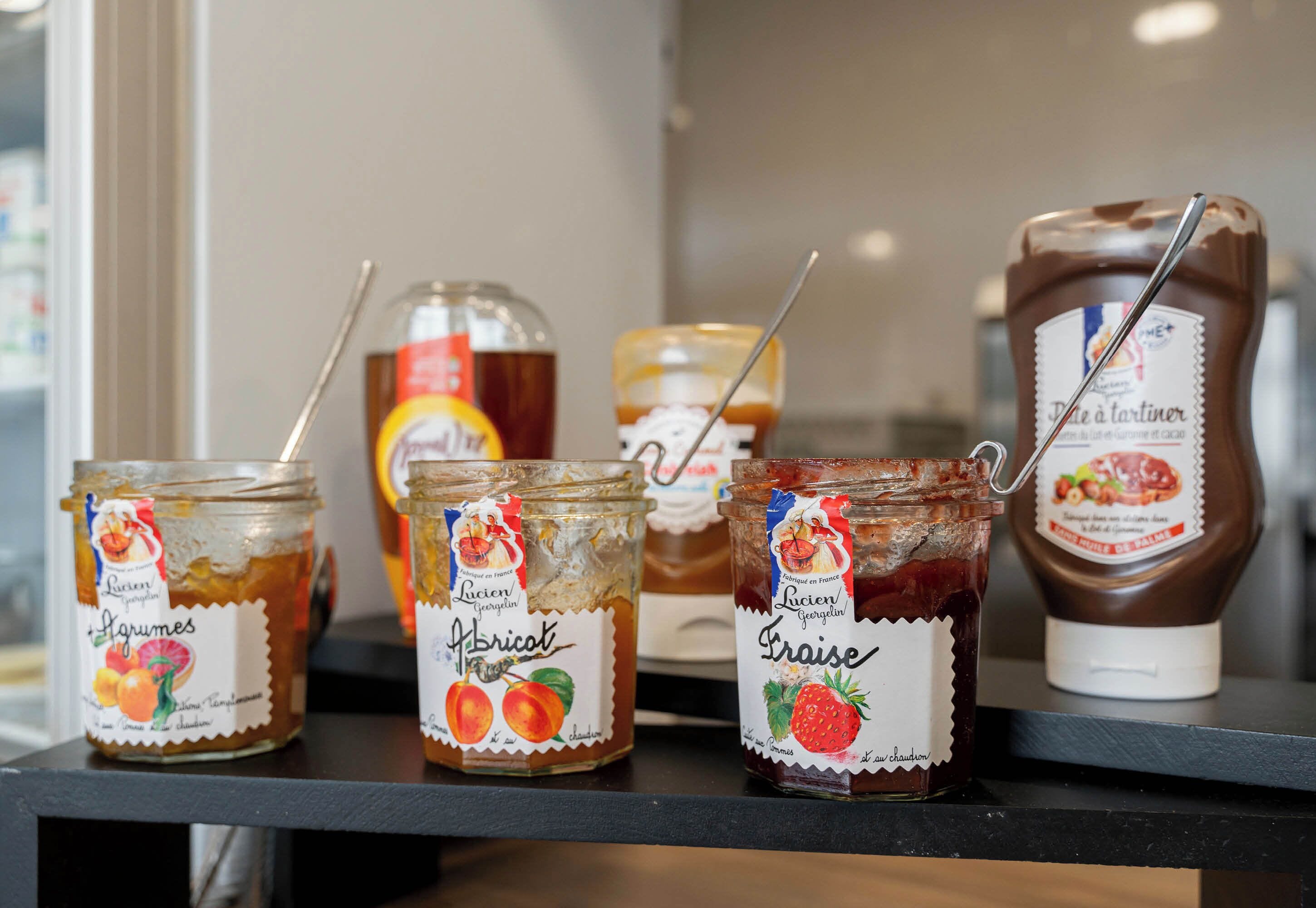 Drie potten jam op een plank.
