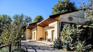 A modern house with a covered patio, a gravel driveway, and a variety of plants. - aCasaMia Wine Resort - Borgo Salella (San Cipriano Picentino)