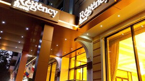 The exterior of the Regency Hotel with illuminated signage and a modern architectural design. - Regency Hotel (Chisinau)
