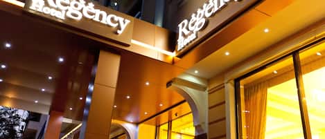 The exterior of the Regency Hotel with illuminated signage and a modern architectural design.