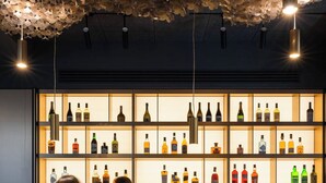 A bar with a wooden ceiling and shelves of bottles. - Regency Hotel (Chisinau)