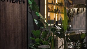 A modern interior with a dark wooden wall, a sign reading "UMBRA," and a seating area with a round table and two chairs. - Regency Hotel (Chisinau)