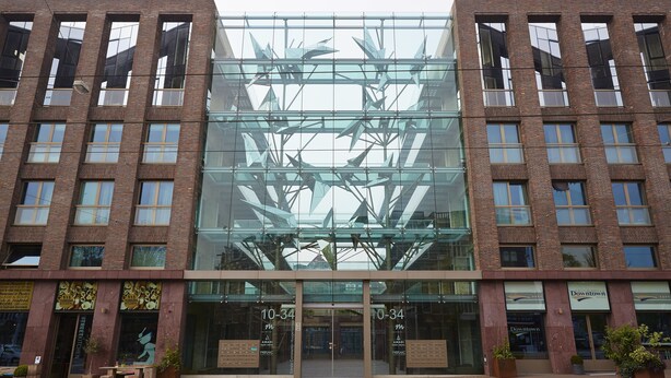 A modern building with a glass facade and a brick exterior. - Amadi Park Hotel (Amsterdam)