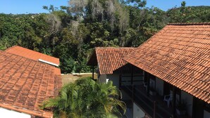 A courtyard with tiled roofs, a staircase, and outdoor seating. - Barla Inn Suites (Búzios)
