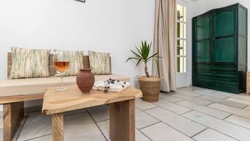 Un salon chaleureux avec une table en bois, un canapé orné de coussins à rayures, une plante en pot et un meuble vert.