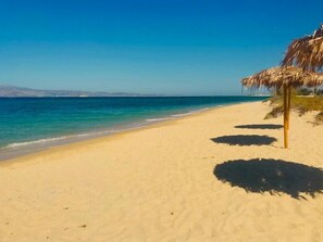 On the beach, white sand, free beach cabanas, beach umbrellas