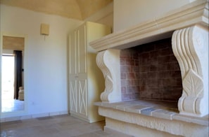 A room with a fireplace, a door, and a tiled floor.