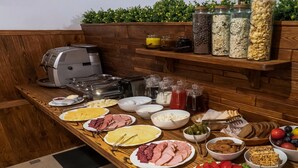 A buffet table with various food items and condiments. - Geneva Resort Hotel (Odesa)