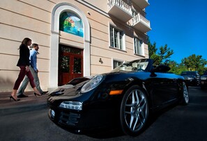 Un descapotable negro estacionado frente a un edificio con un letrero que dice 'GENEVA'.
