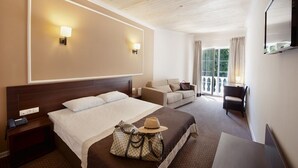 A hotel room with a large bed, a smaller bed, a desk, and a TV. - Geneva Resort Hotel (Odesa)