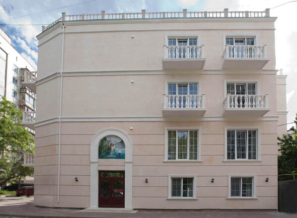 Un edificio de varios pisos con fachada simétrica, balcones y una entrada central con puerta.