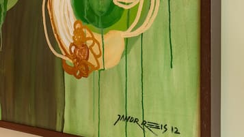Un cuadro abstracto enmarcado con patrones arremolinados y una firma.