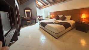 A hotel room with a bed, bedside tables, a desk with a chair, a mirror, and a TV. - Blu Inn Hotel (Bogotá)