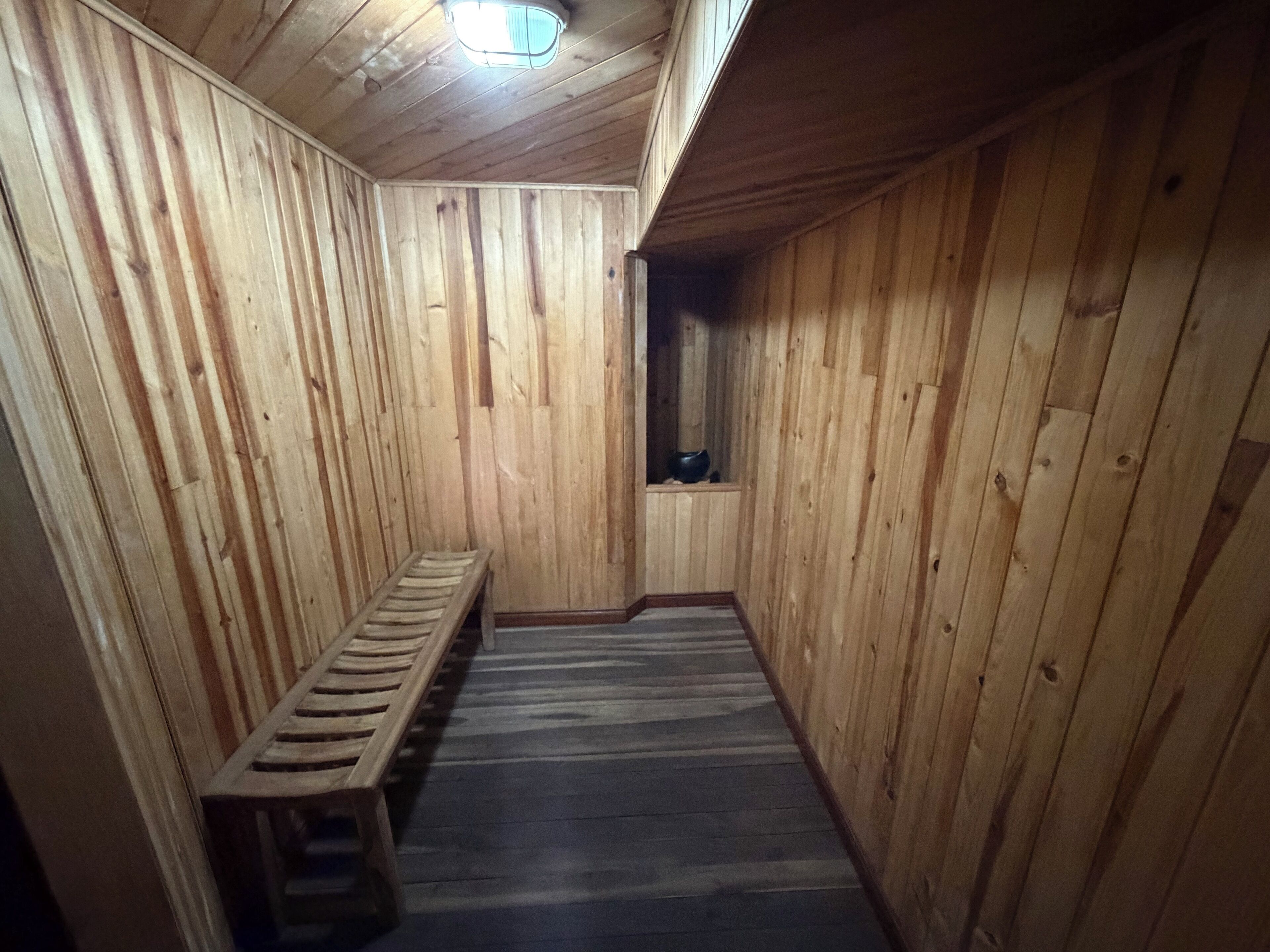 Un sauna de madera con bancos y tragaluces.