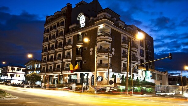A multi-story hotel with balconies, a central entrance, and a street view with traffic lights. - Blu Inn Hotel (Bogotá)