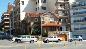 A hotel with a stone facade, multiple balconies, and a sign indicating it is located in Amsterdam. - Hotel Amsterdam (Mar Del Plata)