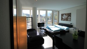 Een moderne slaapkamer met een groot bed, een bureau en een televisie.