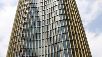 A tall, modern skyscraper with a grid-like facade and reflective glass windows.