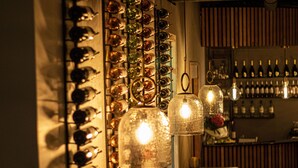 A bar area with a wine rack and hanging lights. - Grand Hotel Downtown (Amsterdam)