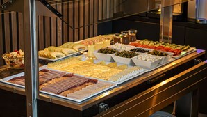 A buffet with various food items including fruits, cheeses, and meats. - Grand Hotel Downtown (Amsterdam)