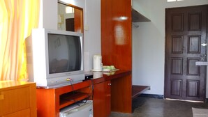 A compact kitchenette with a built-in microwave, a small refrigerator, and a wooden counter. - Thaniza Beachfront Resort (Ko Pha-ngan)
