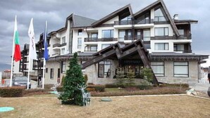 A modern building with a unique sloped roof design, featuring multiple balconies and large windows. - Aspen Resort Golf, Ski & Spa (Razlog)