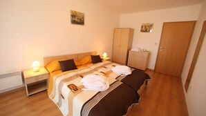 A bedroom with a bed, nightstands, a wardrobe, and a door. - Aspen Resort Golf, Ski & Spa (Razlog)