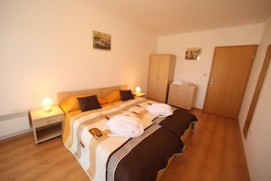 A bedroom with a bed, nightstands, a wardrobe, and a door. - Aspen Resort Golf, Ski & Spa (Razlog)