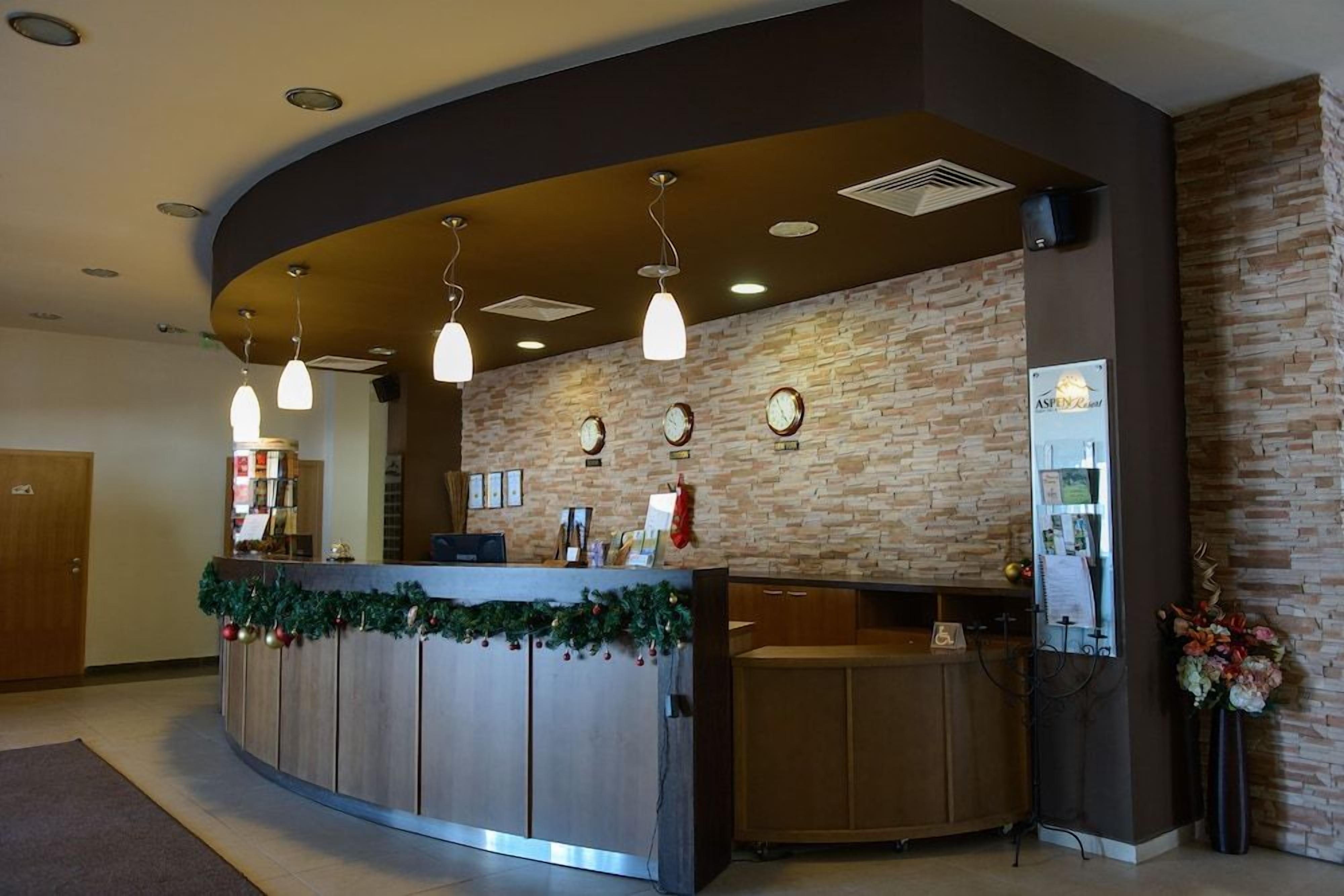 A reception area with a curved counter, multiple clocks, and a wall-mounted sign.