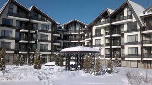 A multi-story hotel with balconies and a covered outdoor seating area. - Aspen Resort Golf, Ski & Spa (Razlog)