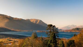 A mountainous landscape with a river and a bridge.