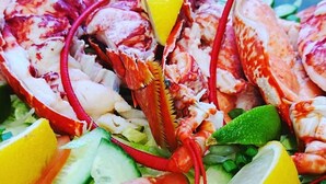 Insalata di aragosta con fette di limone e lattuga.