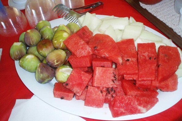 Un plato de frutas que incluye sandía, manzanas y coles de Bruselas.