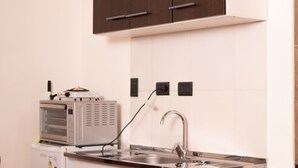 A kitchen with a microwave, a sink, and a stove. - Donna Alda Casa (Salta)