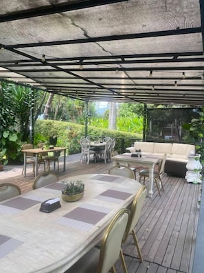 An outdoor patio area with a covered seating area, tables, and chairs. - Hotel Aromax del Campestre (Medellín)